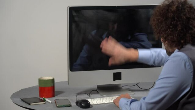 Businessman punches computer and keyboard that doesn't work - problems at work in office and smart working - hysterics against internet and modern technology, online addiction- virus and hackers 