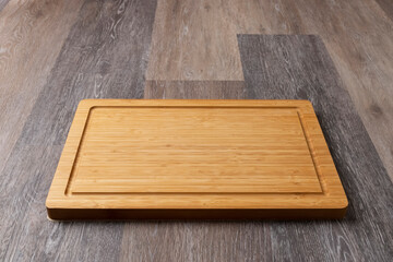 Empty cutting board on a wooden table, close-up, copy space for text.
