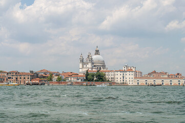 Fototapeta premium View of the Venice Canal embankment on a warm summer day, with floating boats and old houses, Venice, Italy