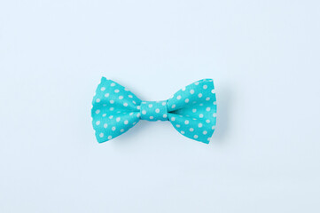Turquoise color bow  with white polka dots on a white background.