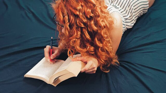 woman studies lying on the bed trying to memorize the salient concepts