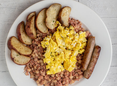 cramble eggs on corn beef hash with  sausage and potatoes,