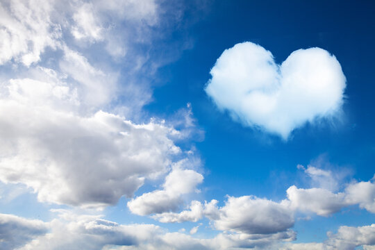 cumulus clouds on blue sky with heart shaped cloud