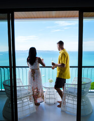 A couple of men and women drinking cocktails on the balcony of a hotel in Pattaya Thailand at...