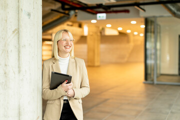 Fototapeta premium Businesswoman with digital tablet on modern office hallway