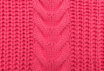 Viva Magenta. Knitted sweater pattern with voluminous braids. Abstract texture. The image is colored in viva magenta 2023. trendy background, new background.