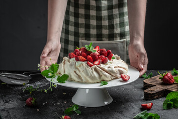 delicious homemade Pavlova cake with fresh strawberries and whipped cream. Female baker decorating delicious meringue cake, Long banner format