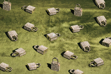A pattern of padlocks with zircons on a plush surface in olive green.