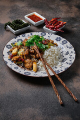Stir-fried crispy pork with rice on dark background