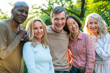 Fun diverse group of middle-aged friends hanging out in backyard at sunset