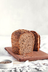 Loaf of sliced rye bread with seeeds on a wooden board. Copy space.