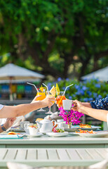 Breakfast and hands clinking drinks,Group of people having brunch together at table, top view
