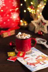 Christmas cup of cocoa with marshmallows on a wooden table on the background of Christmas decor.New Year's mood.