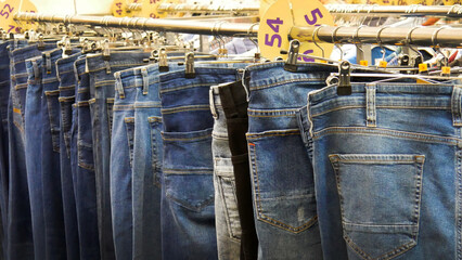 Close-up of many various jeans hanging on a store rack