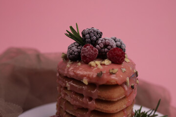 sweet fragrant lush pink heart-shaped pancakes with pink delicious icing on top and decorated with raspberries and blackberries with green rosemary sprigs. for signage, menu labels, and more