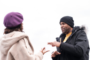 Deaf afro american man is using sign language to talk his friend.