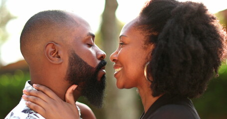 African couple in love kissing outside wiht lens-flare