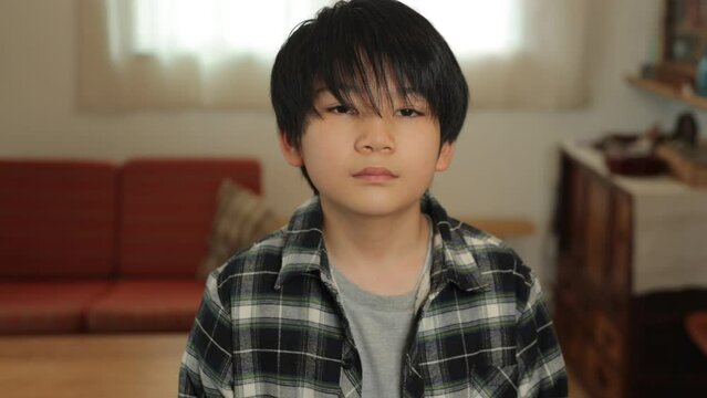 Asian teenage boy opens his eyes and stars the camera. Loneliness, Sadness, Emotionless. Dolly out.