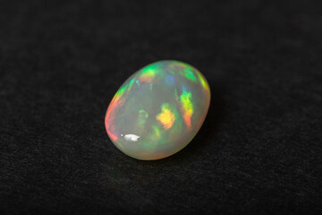Obraz na płótnie Canvas Colorful milky opal gem on black background