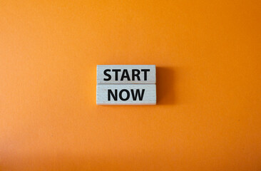 Start now symbol. Wooden blocks with words Start now. Beautiful orange background. Business and Start now concept. Copy space.