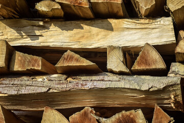 Chopped firewood is stacked in neat piles. Woodpile. Background. Close-up. Selective focus.
