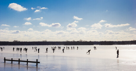 Silhouettes of skaters on the frozen lake in Paterswolde, Netherlands