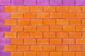 Orange and purple paint on brick blocks urban color vibrant design wall texture background architecture