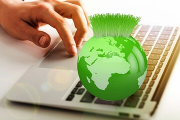 .Laptop keyboard and Green Globe with plant