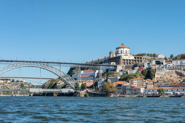Obraz premium Partial view of the impressive Dom Luise I arch bridge connecting the historic district Ribeira and Vila Nova de Gaia neighborhood as seen from Douro River waters in Porto, Porgual