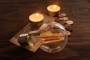 Concept of loadshedding. South African rand with candles and light bulb in background . Rising energy costs 
