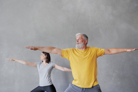man and woman do yoga in sports studio, hero pose. senior coach and young adult female meditate, exercise. relaxation, relaxation practices and health care