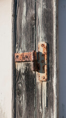 Bisagra oxidada en puerta rústica de madera