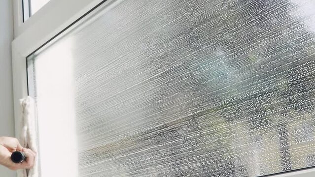 A professional cleaning service worker washes the windows with special foam and cleans them.