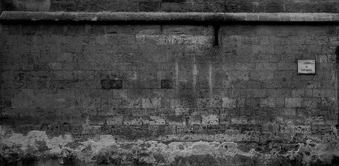 old abandoned wall om a street with structure and pattern, in black and white landscape format 