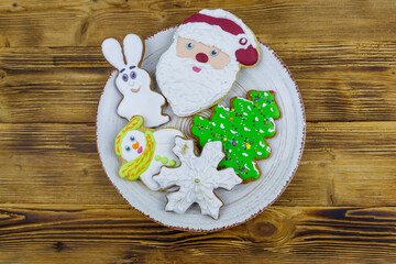 Christmas gingerbread cookies in a plate on a wooden table. Top view