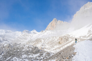 Fototapeta na wymiar alpinist clibing a snowy mountain in winter
