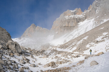 alpinist clibing a snowy mountain in winter