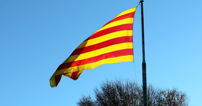 Large Red And Yellow Flag Of Catalonia Waving In The Wind With Blue Sky Background. Close Up View - DCi 4K Resolution
