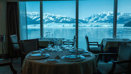 Empty restaurant seating interior with panoramic windows at scenic glacier bay nature