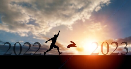 Obraz premium Silhouette running business man with bunny at sunset.