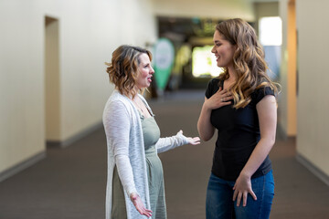 A young woman and her youth leader discussing their faith in a hallway of a church: Edmonton, Alberta, Canada