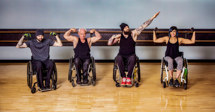 A group of paraplegic friends fooling around showing their muscles after a workout in fitness facility: Sherwood Park, Alberta, Canada