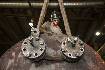 Bolting up the face plate of a line heater for pneumatic test, with the line heater coil installed into a line heater bath; Innisfail, Alberta, Canada