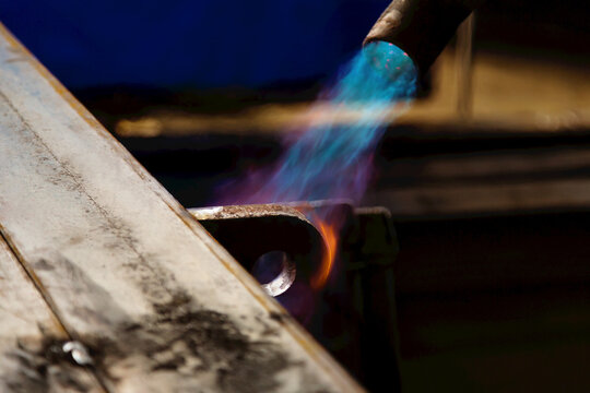 Pre-heating steel beam with a lift lug using a torch; Innisfail, Alberta, Canada