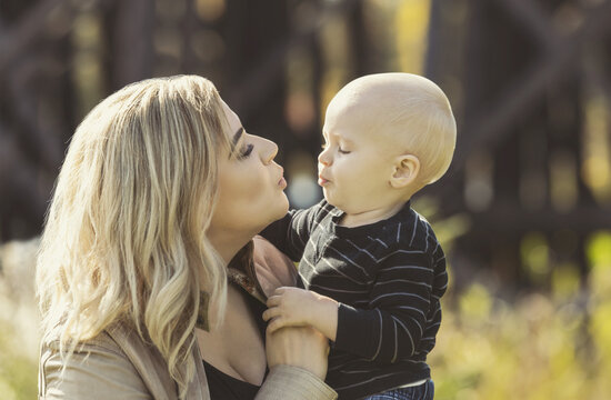 A mother and her son enjoying a day outdoors in a city park during the fall season; St. Albert, Alberta, Canada