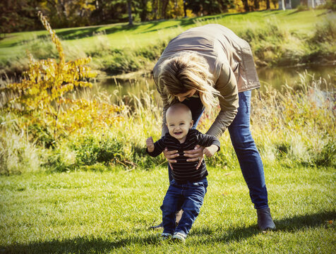 A mother and her son enjoying a day outdoors in a city park during the fall season; St. Albert, Alberta, Canada