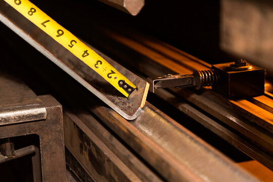 A tape measure measures length of a sheet metal component for material preparation; Innisfail, Alberta, Canada