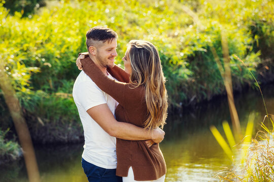 Husband and wife spending quality time together outdoors near a stream in a city park; Edmonton, Alberta, Canada