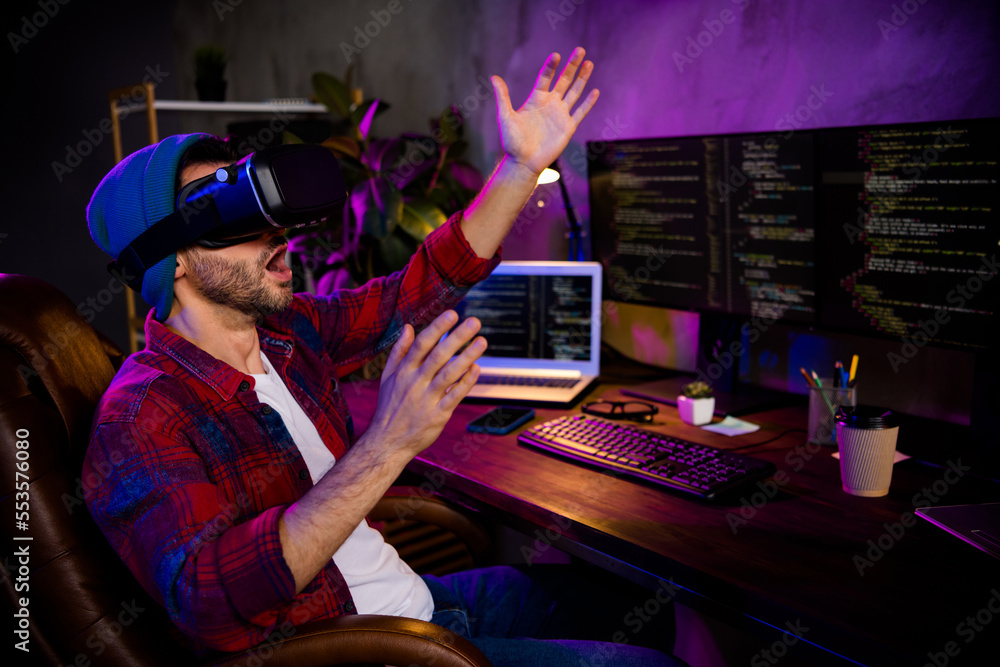 Poster photo of smiling funny coder dressed hat eyewear creating video 3d game modern gadget indoors workpl