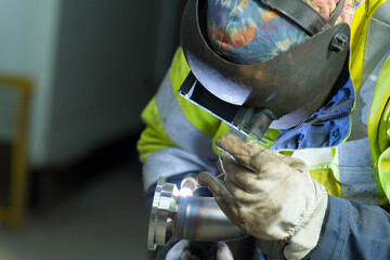 worker wearing visor welding metal pipe - obrazy, fototapety, plakaty